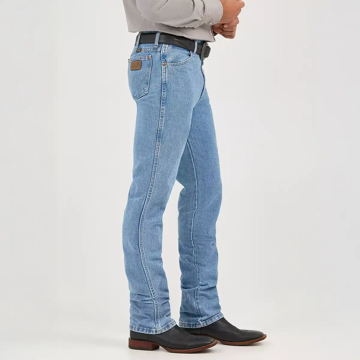 Side profile view of a man wearing Wrangler 0936 slim fit antique wash jeans showing the high rise and tapered boot-cut leg.