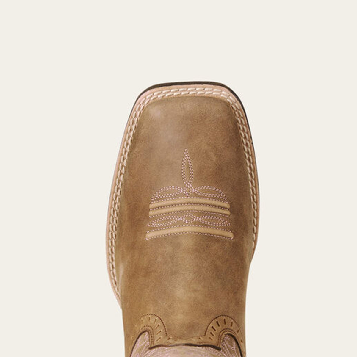 Close-up of a Ariat tan brown square toe with stitching detail on a beige background.