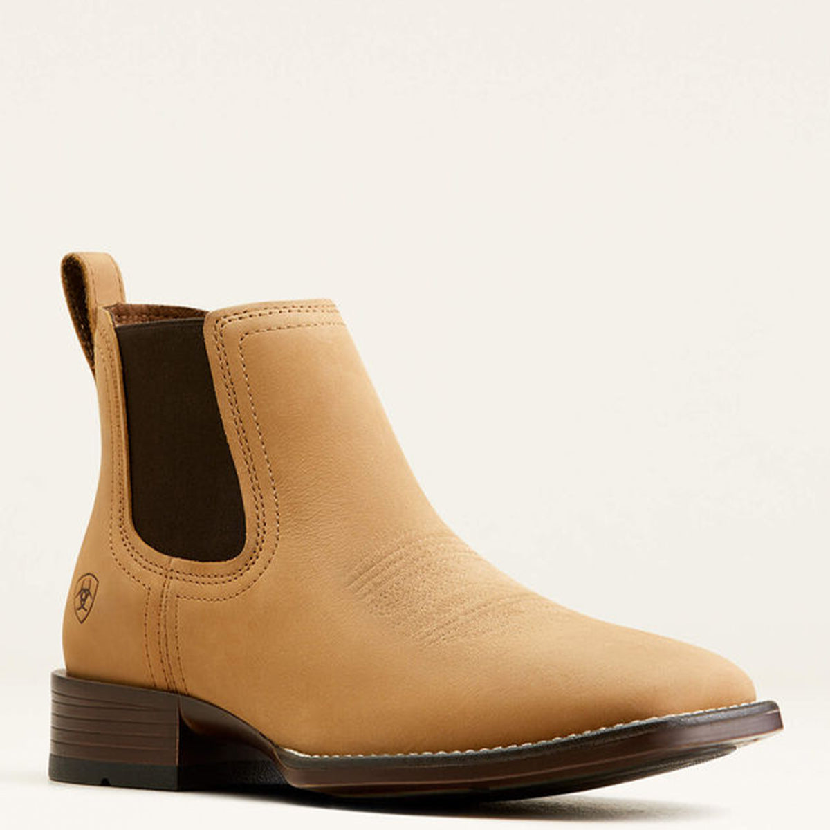 Ariat men's tan leather Chelsea boot with a dark brown elastic side panel and a low dark brown block heel, shown from a side profile on a light beige background.