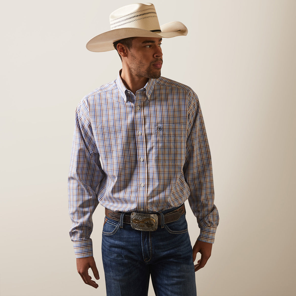 Front view of a man wearing the Ariat Men's Wrinkle Free Arther blue and brown plaid long sleeve shirt.