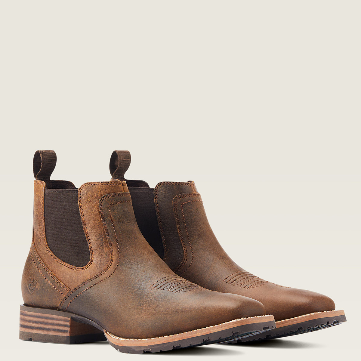 Ariat Men’s Hybrid Low Boy Square Toe Western Ankle Boots in Old Earth brown leather featuring elastic side panels, front and back pull tabs, and a grippy rubber outsole.