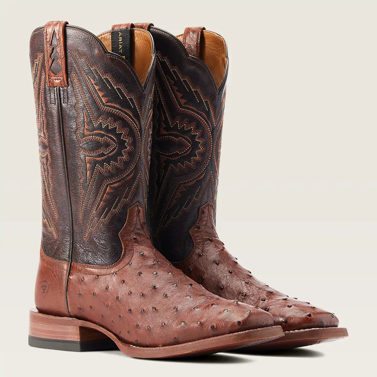 A pair of men's brown full quill ostrich leather western cowboy boots shown on a light beige background.