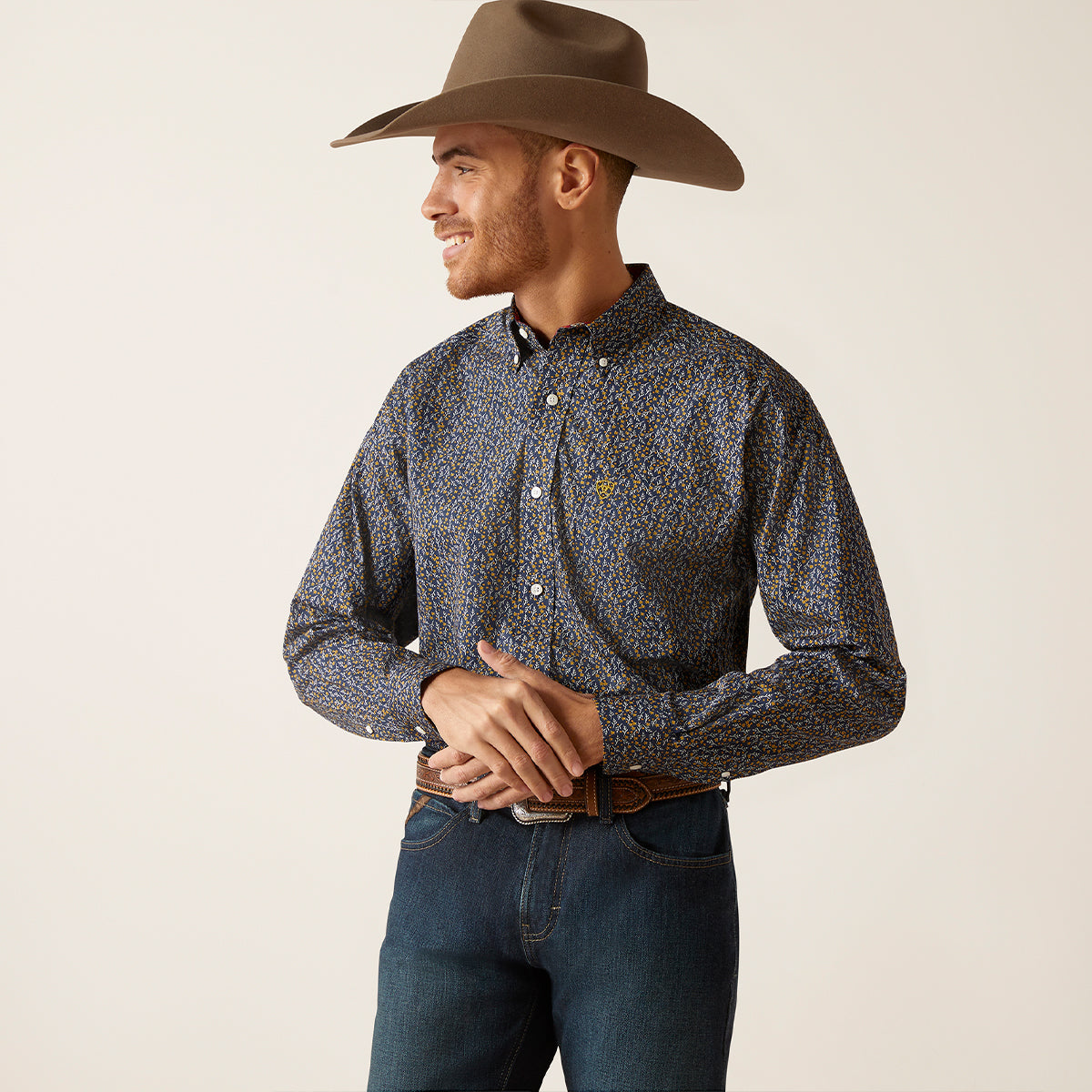 Front view of a man wearing the Ariat Men's Wrinkle Free Kolson Deep Pacific floral shirt.