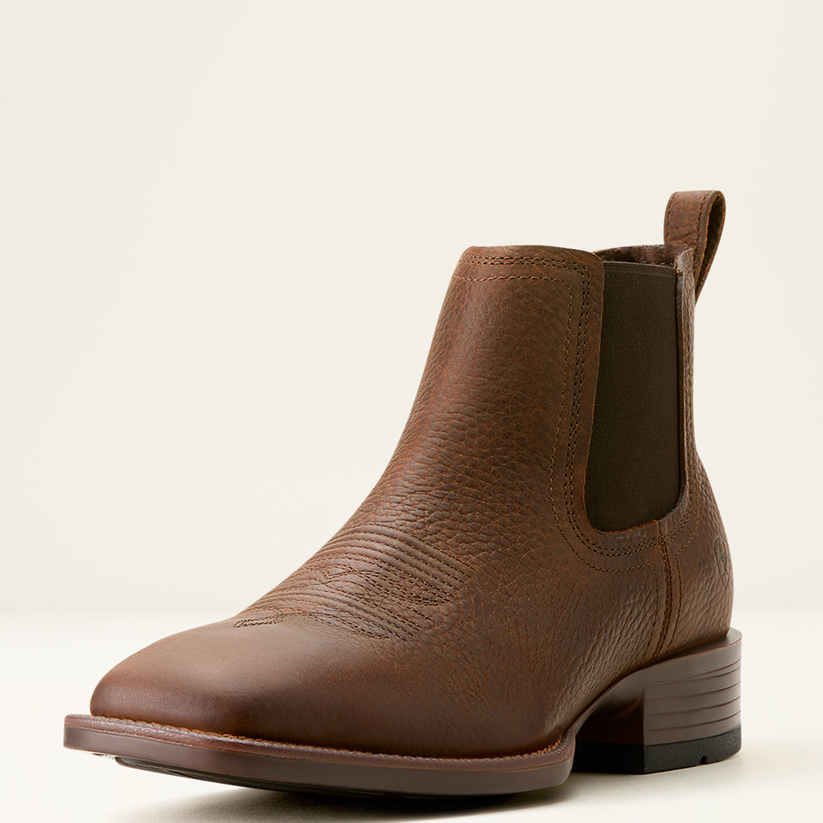 Ariat Men’s Booker Chelsea cowboy boot in Brown Oiled Rowdy pebbled leather featuring elastic side panels, front and rear pull tabs, and a square toe profile.