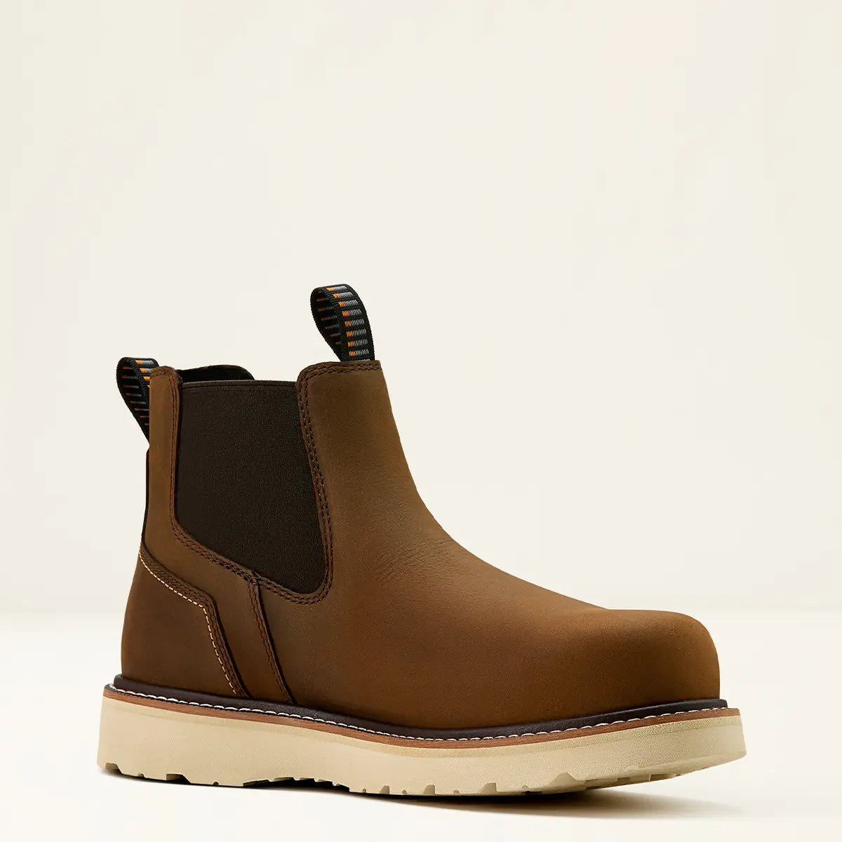 Three-quarter studio profile of the Ariat Men's Rebar Wedge Chelsea boot in distressed brown leather showing the elastic goring, pull loops, and cream wedge sole.