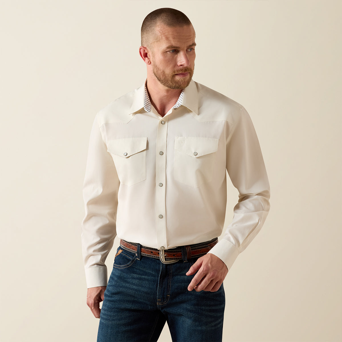Front view of a man wearing the Ariat Men's Off White Pinpoint Oxford long sleeve Western snap shirt.