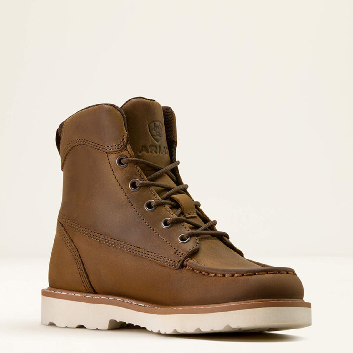 Kid's Ariat brown leather boot with white sole on a beige background.