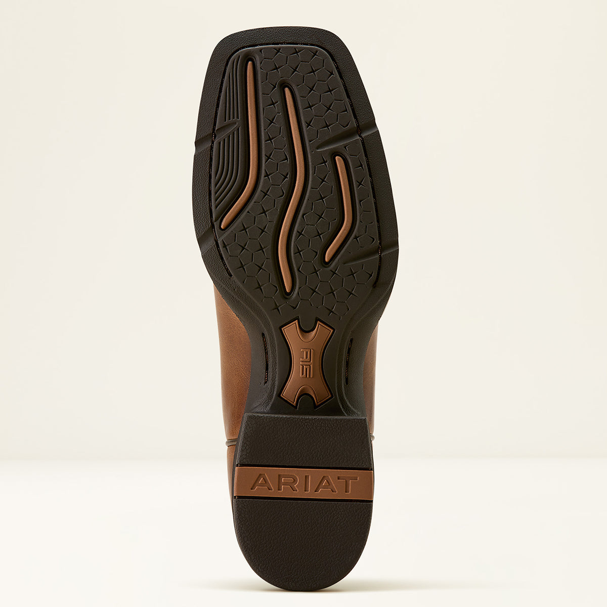 The outsole of an Ariat boot shown from a top-down view, featuring a black treaded rubber sole with brown accents and the brand name 'ARIAT' embossed on the heel.