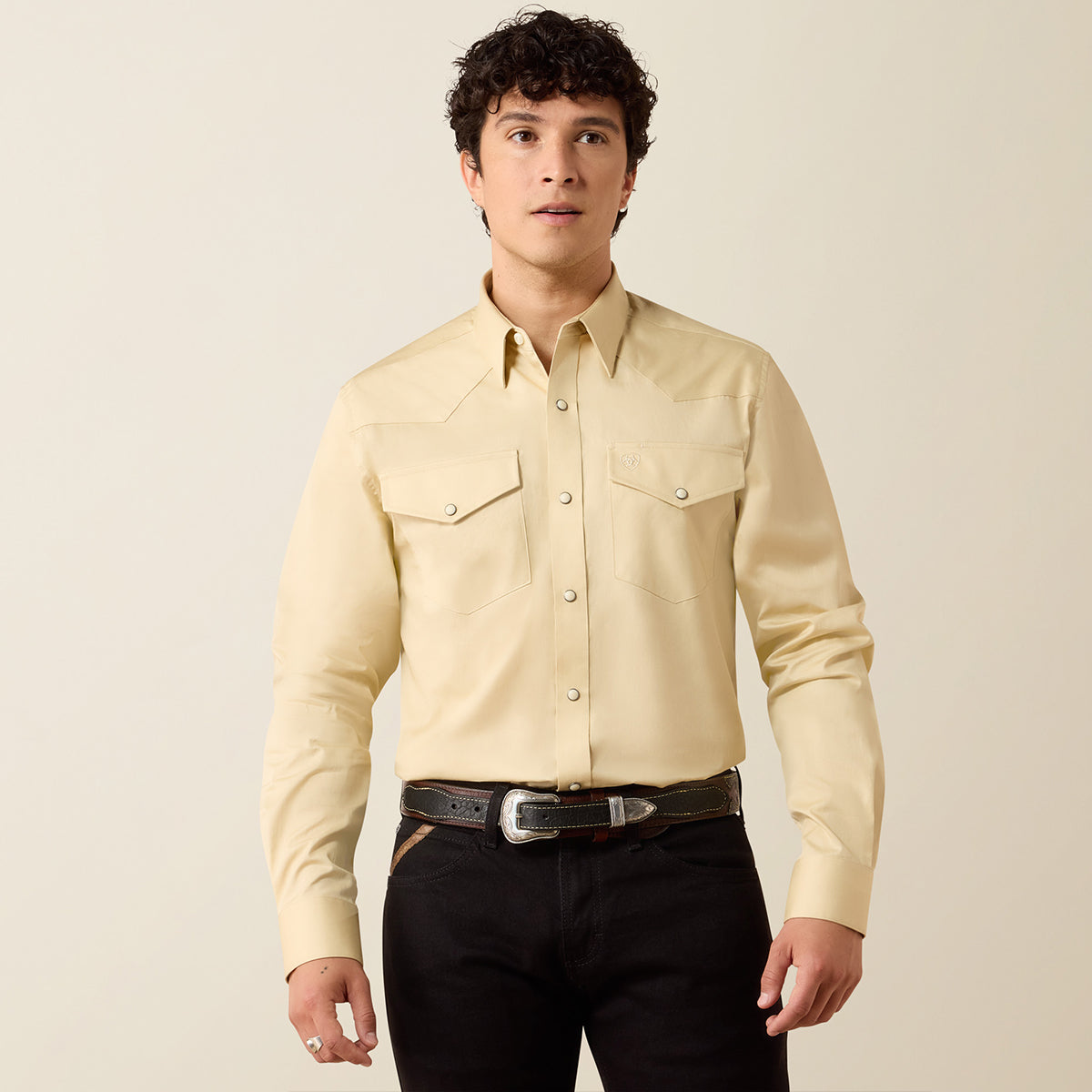 Front views of a man wearing the Ariat Men's Solid Twill Fitted Off-White long sleeve Western snap shirt with black jeans.