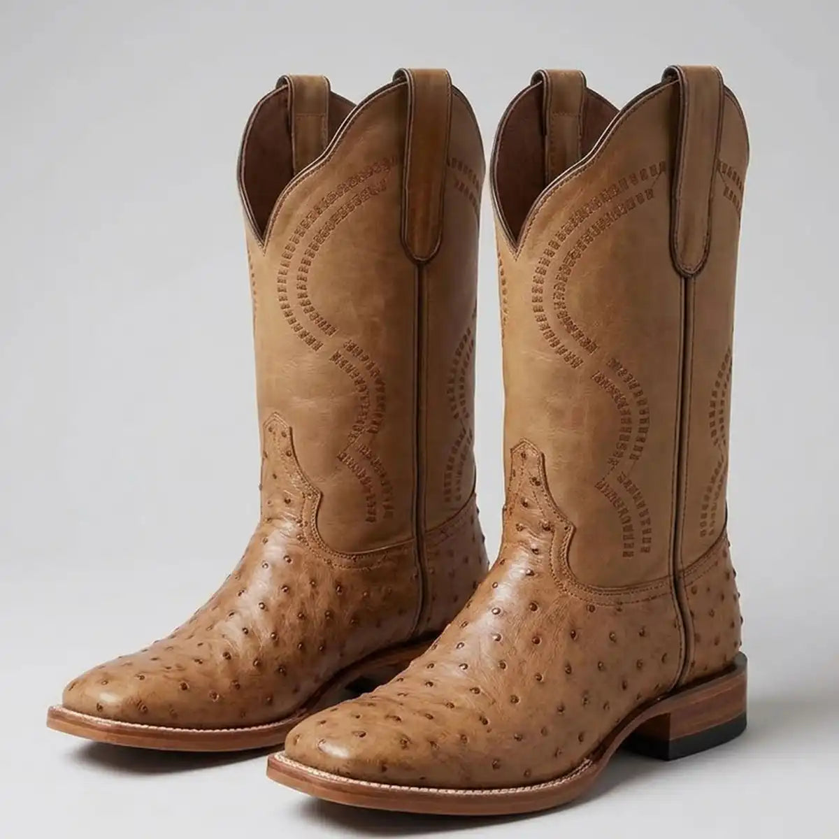 Pair of White Diamonds Boots men's Oryx tan ostrich print square toe cowboy boots displayed on a light background.