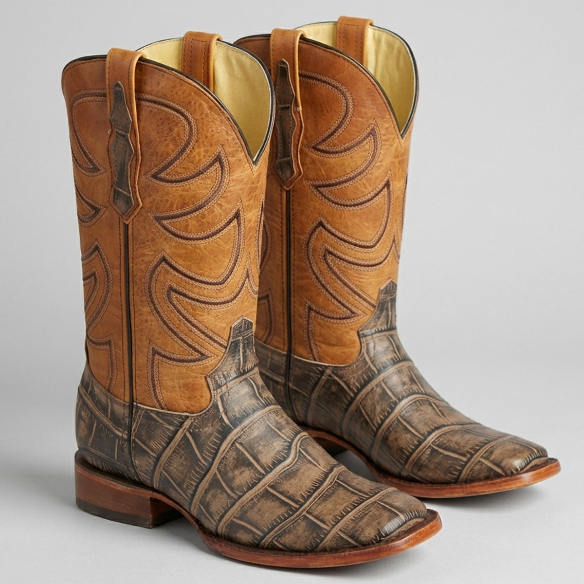 Pair of men's brown square toe cowboy boots with Alligator print design.