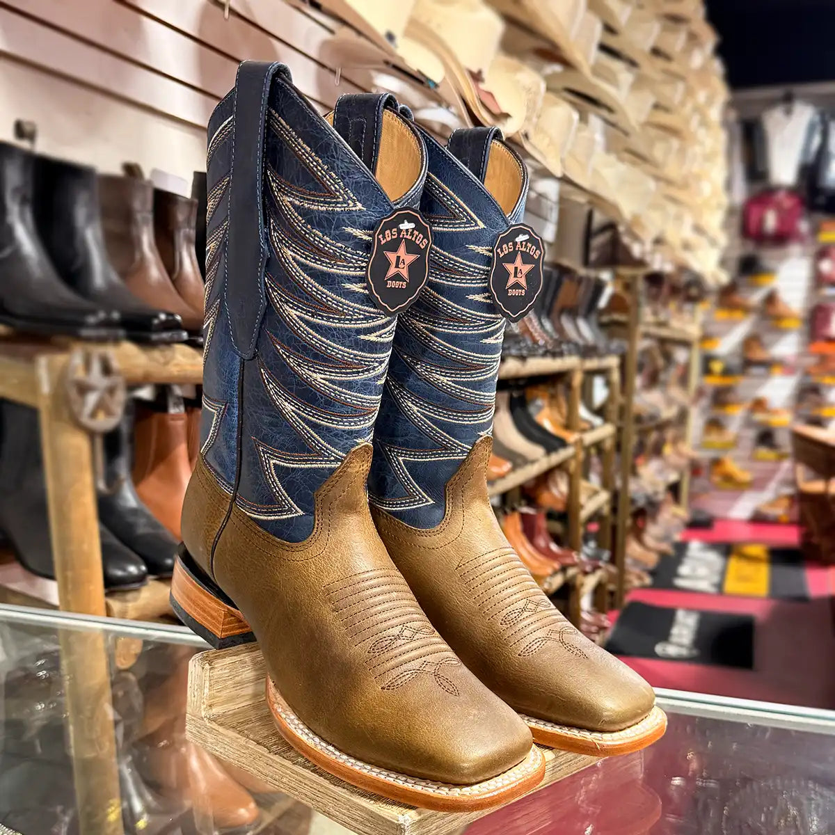 Pair of Los Altos Men's Honey brown leather square toe cowboy boots with vibrant blue embroidered leather shaft.