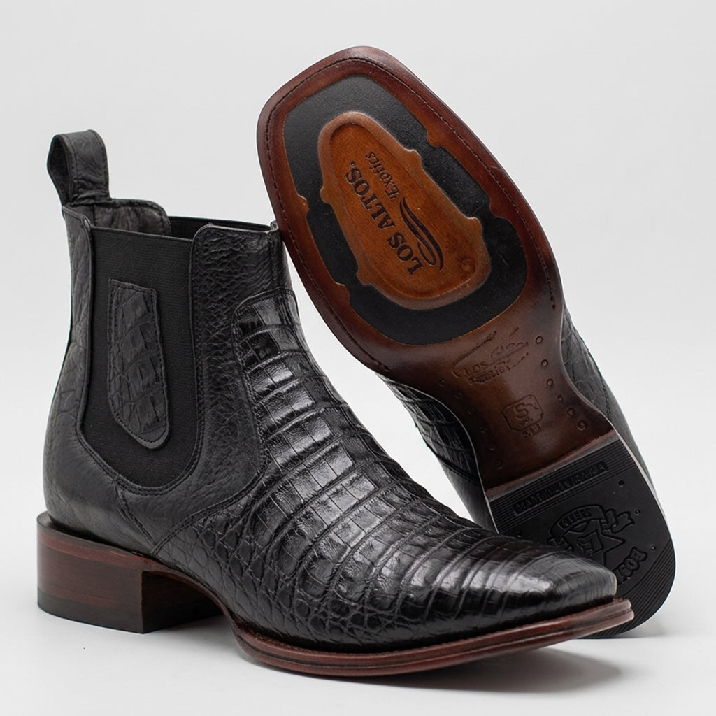 Los Altos men's black caiman belly leather ankle boots with elastic side panels, shown with one boot upright and the other turned to display the brown sole. The brand name 'Los Altos' is visible on the sole.