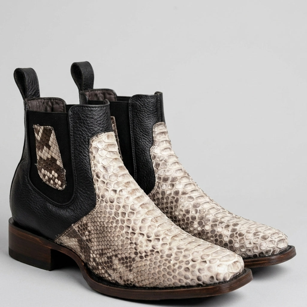 A pair of Los Altos men's Chelsea-style ankle western boots featuring a black leather side panel and pull tabs, combined with a beige and brown snakeskin-patterned toe and quarter panels, set against a neutral light gray background.