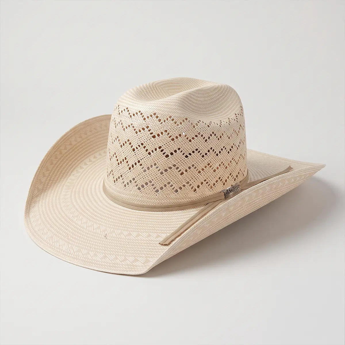 Studio three-quarter view of the Abolengo 30X Shantung Minnick Mountain straw cowboy hat on a neutral background showing the ventilated crown and tan ribbon hatband.