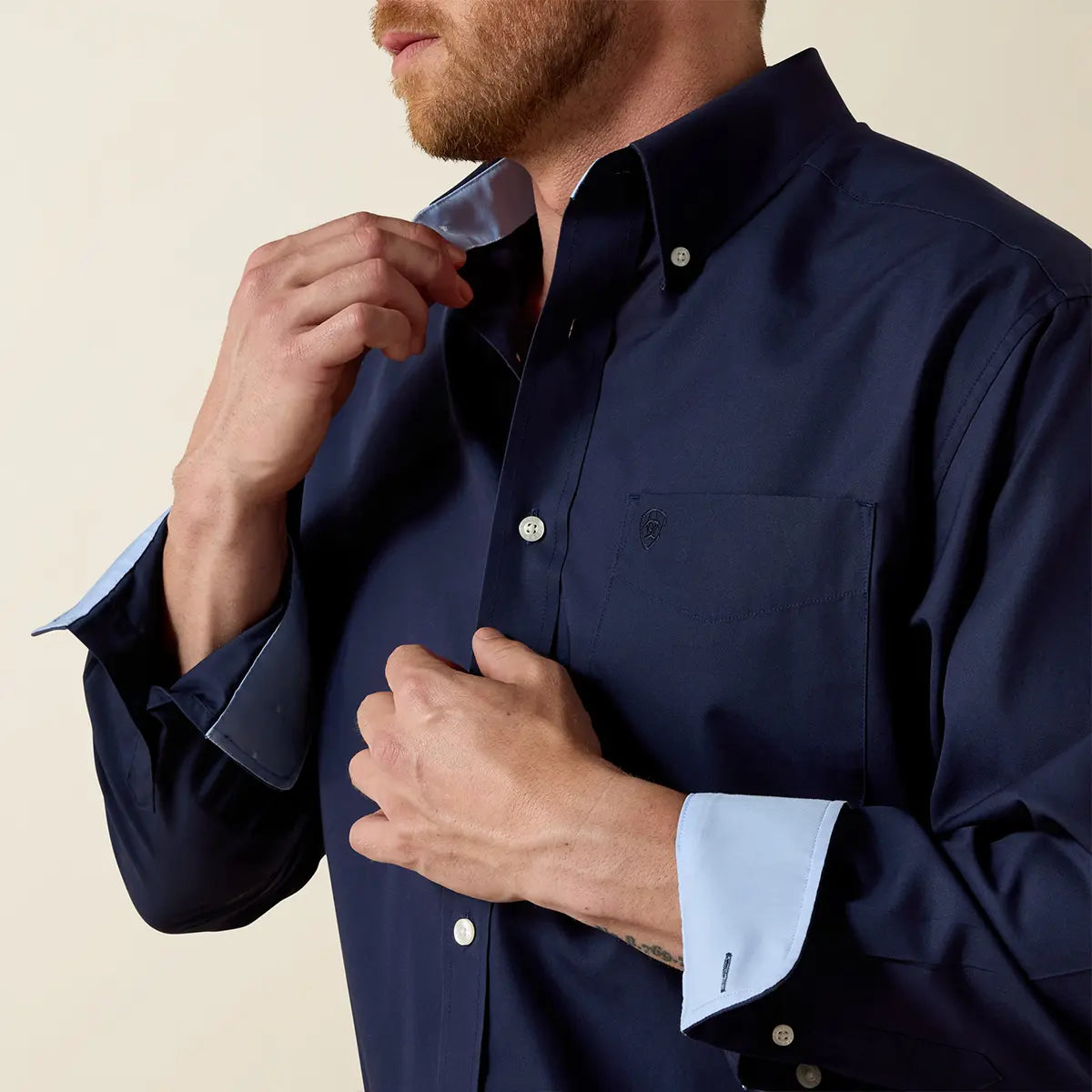 Close-up view of the Ariat navy blue shirt showing the unbuttoned cuffs flipped back to reveal the light blue interior contrast lining.