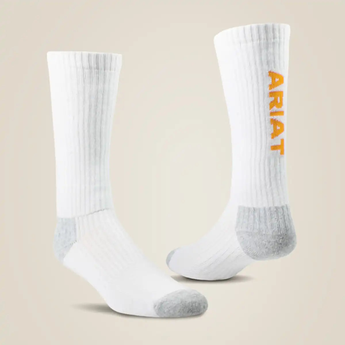 Pair of Ariat white mid crew work socks showcasing gray reinforced heel and toe caps with vertical orange Ariat lettering along the upper shaft.