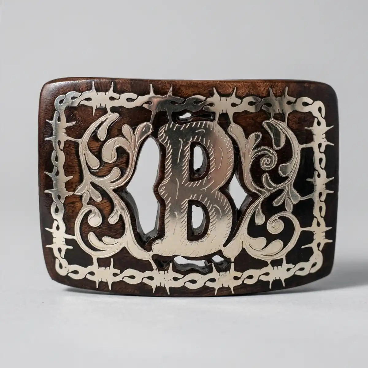 Studio white background view of the mesquite wood western belt buckle highlighting the polished B letter and intricate scrollwork.