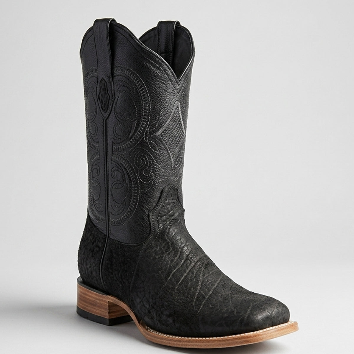 Men's black bull shoulder leather cowboy boot with intricate design on a light gray background.