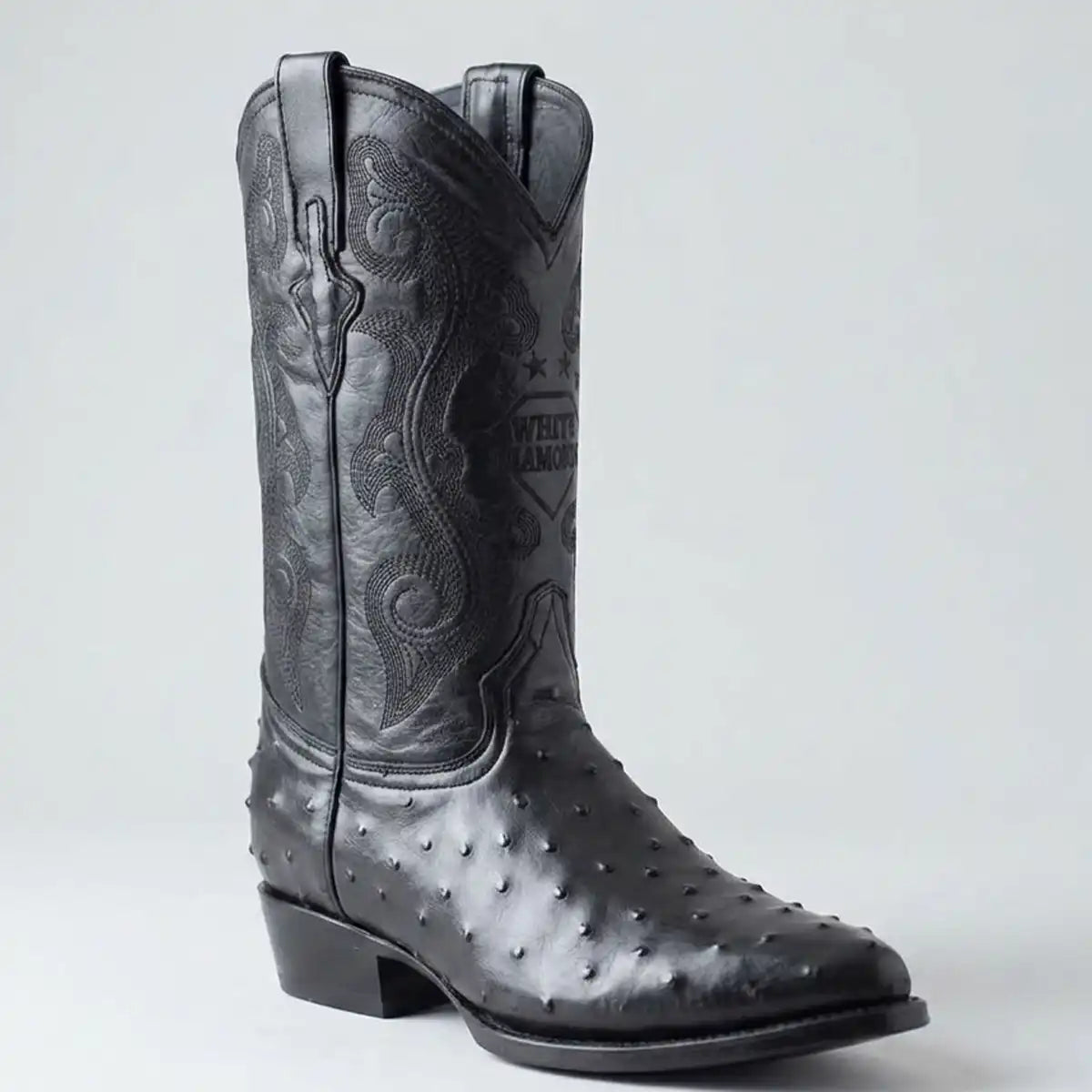 Single boot profile shot of the White Diamonds black ostrich print J-toe boot highlighting the 1.5" cowboy heel and 11" shaft.