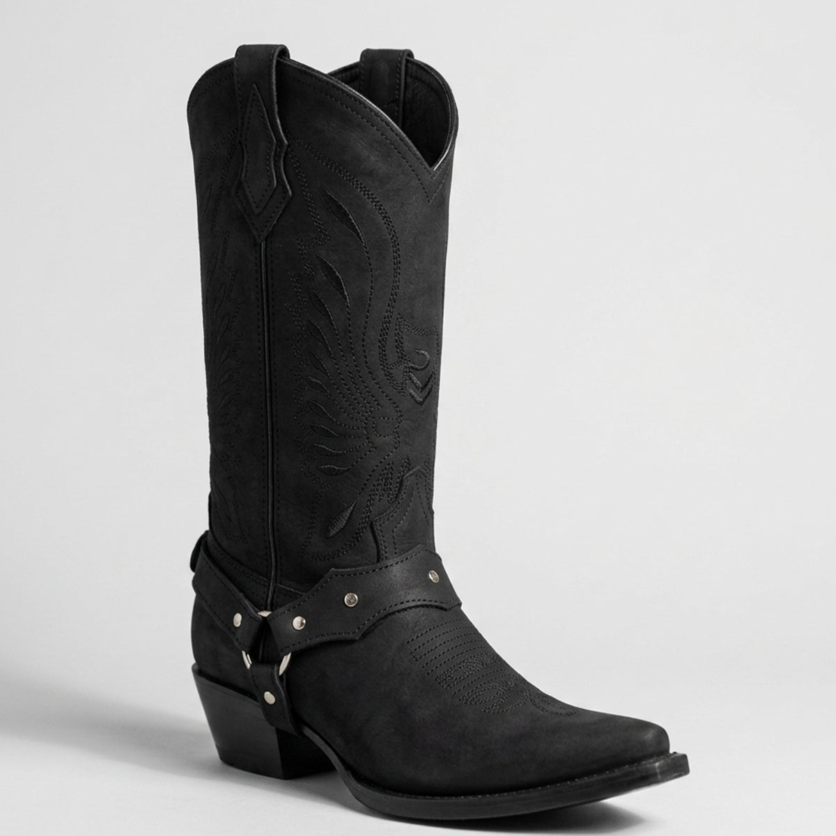 Pair of La Sierra women's black matte leather cowboy boot with pointed toes, studded harness straps, and subtle Western embroidery on the shaft.