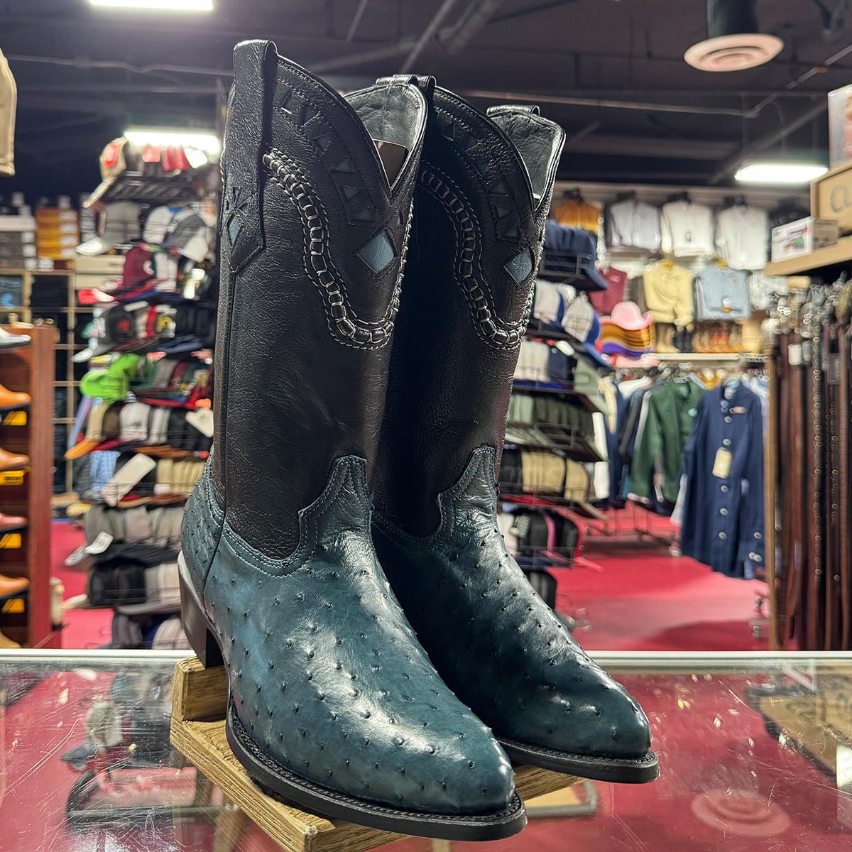 Pair of blue ostrich cowboy boots on display in a store.