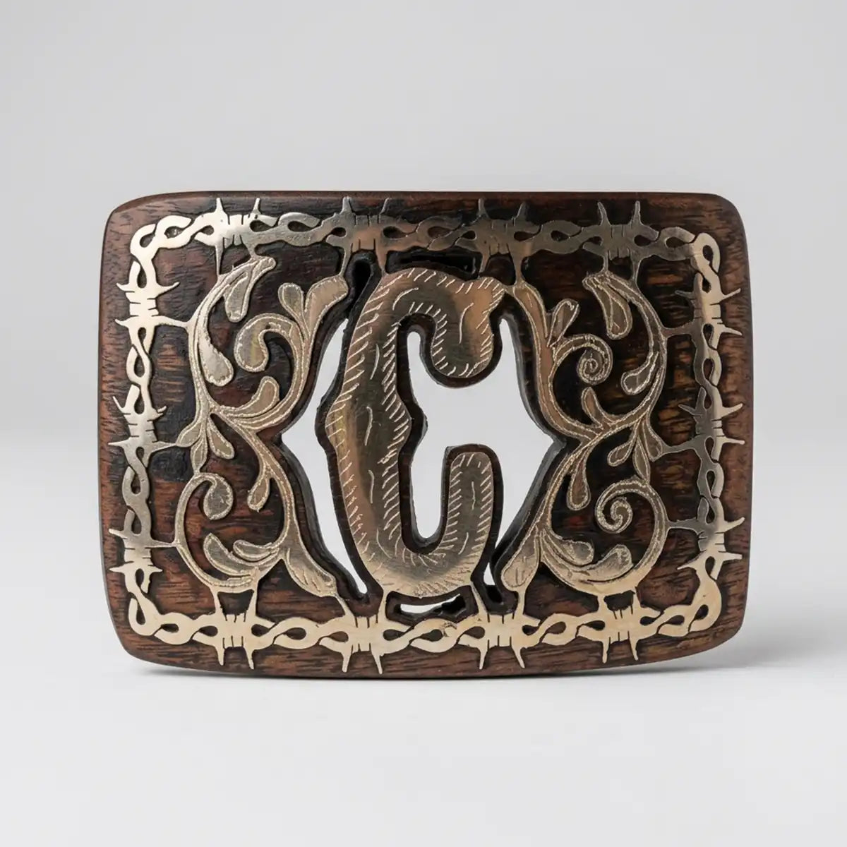 Studio white background view of the mesquite wood belt buckle highlighting the polished C letter and intricate scrollwork.