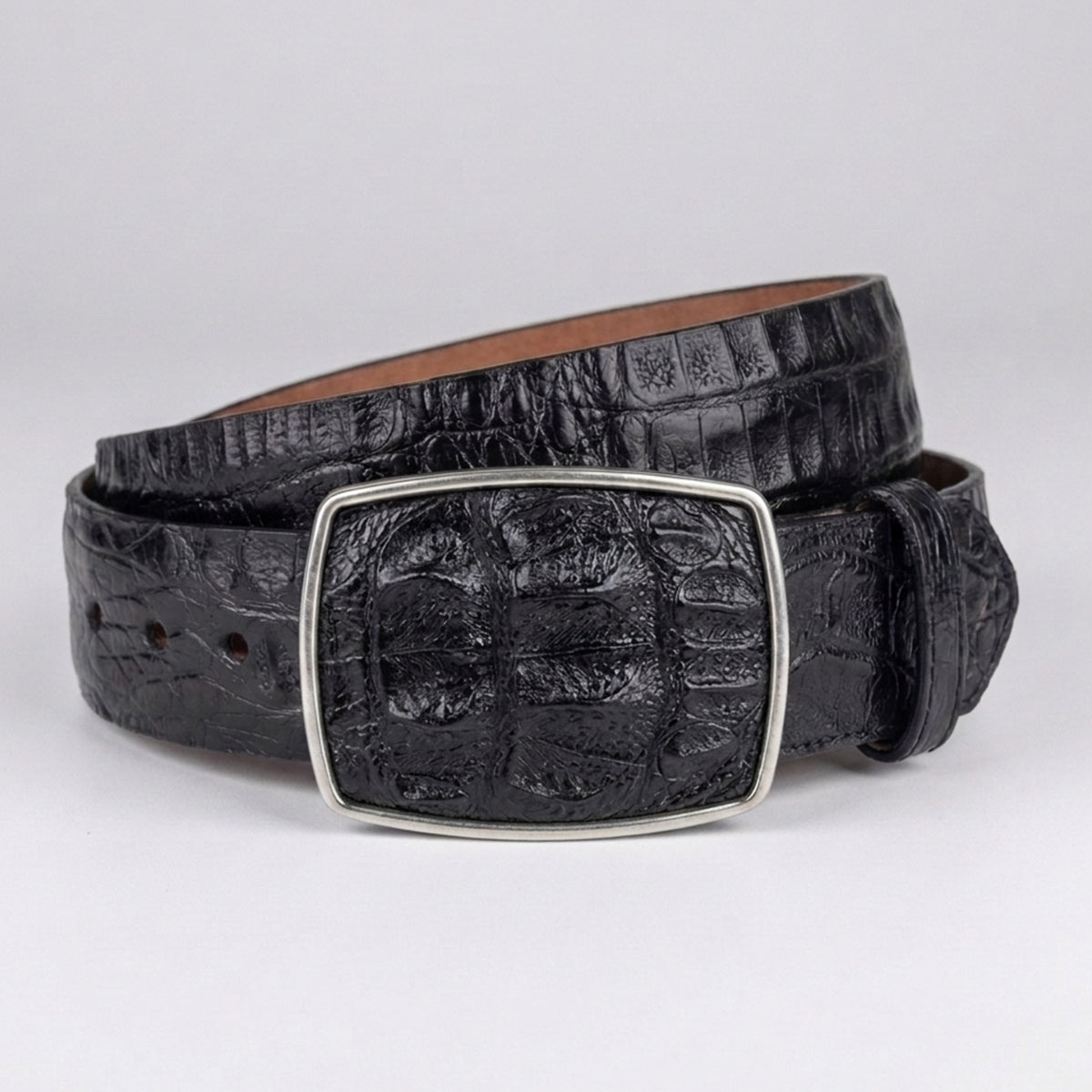 Los Altos men's black crocodile horn-back leather belt with a silver-toned rectangular buckle, coiled on a light gray background.