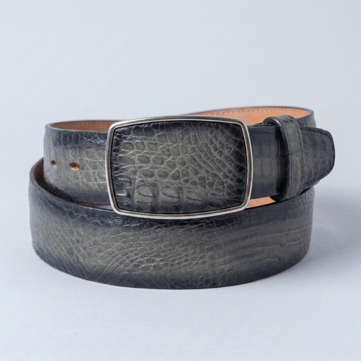 Los Altos men's burnished gray caiman belly leather belt with a silver-tone rectangular buckle, coiled on a light gray background.