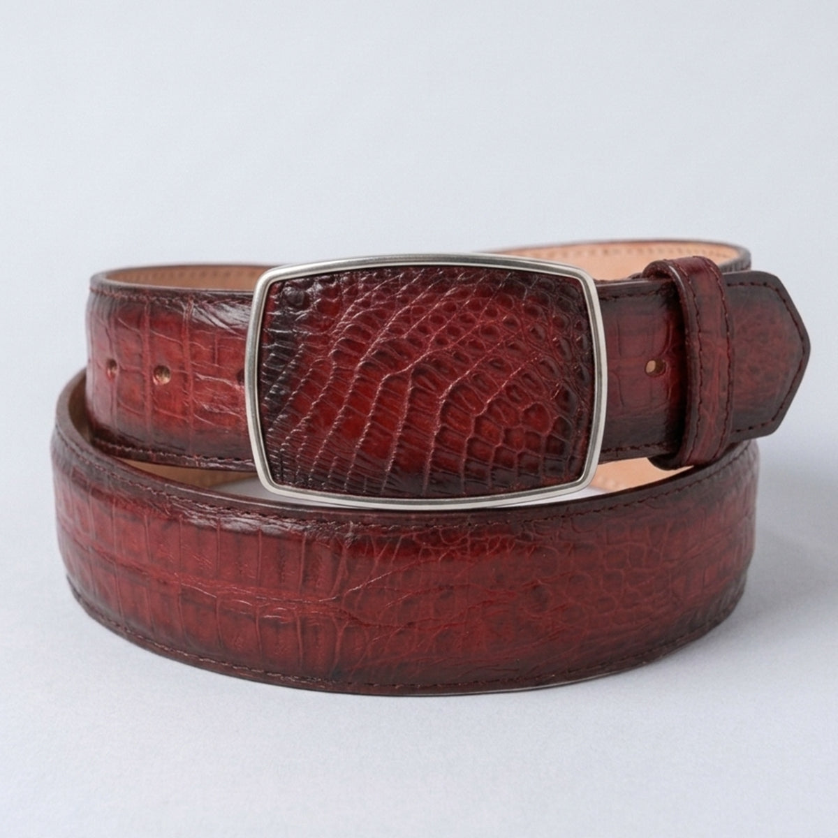 Los Altos men's faded burgundy genuine caiman belly leather belt featuring rich red-wine tile scales and a matching rectangular silver-framed inlay buckle.