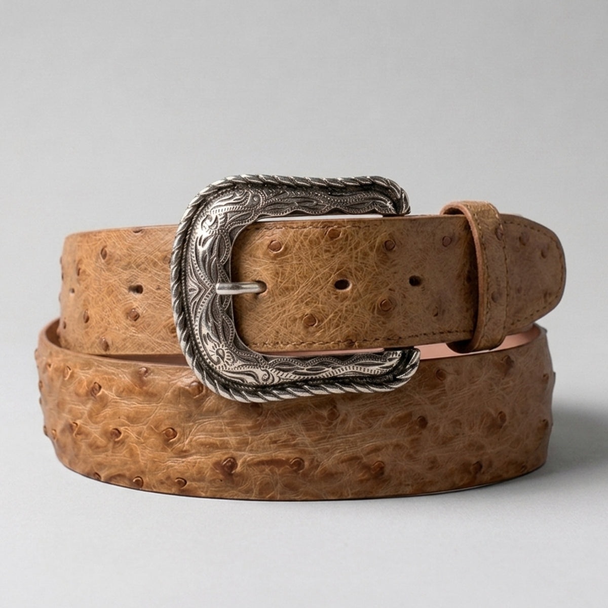 Los Altos men's amber tan full quill ostrich leather belt with a silver-tone western heel-bar buckle, coiled on a light gray background.