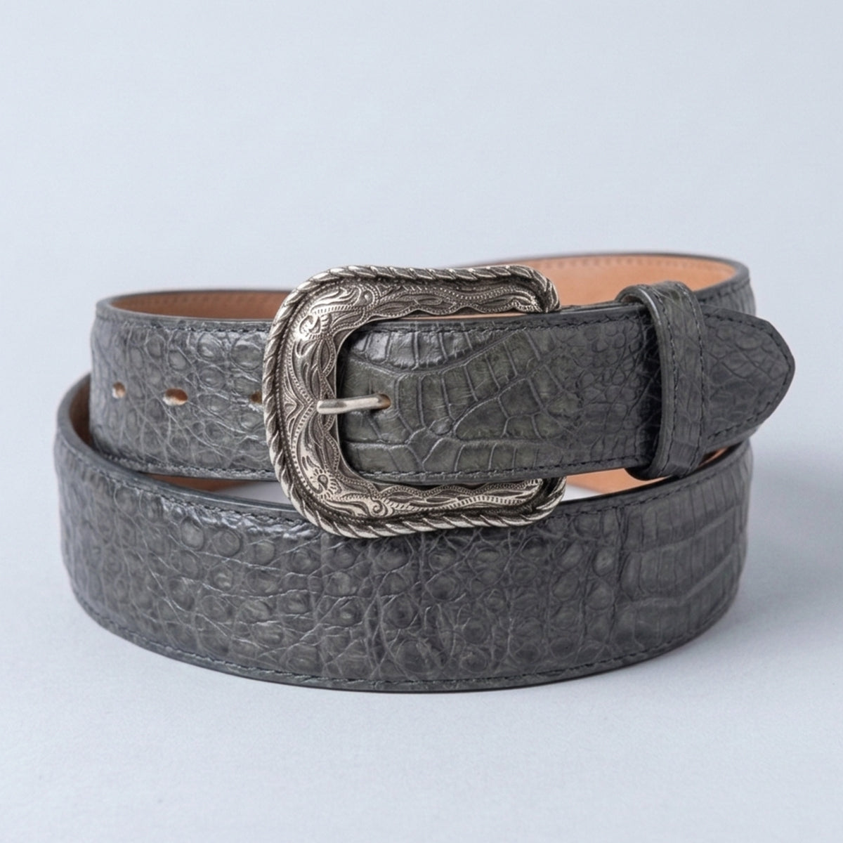 Los Altos men's gray caiman belly leather belt with a silver western heel-bar buckle, coiled on a light gray background.
