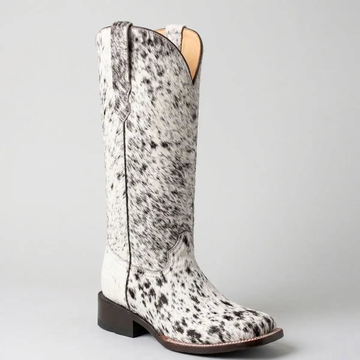 Single Botas Doble R women's cowgirl boot featuring a black and white speckled hair-on hide finish, square toe, deep V-cut collar, and dark block heel against a light studio background.