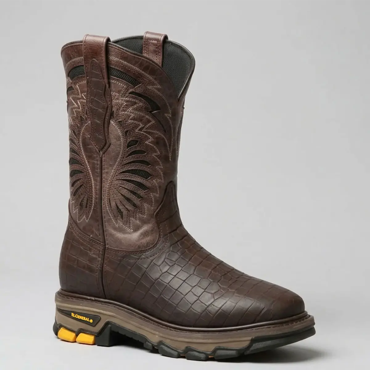 Studio angled view of the El General men's chocolate brown caiman print square toe work boot displaying the embossed leather foot, tractor rubber outsole, and embroidered upper shaft.