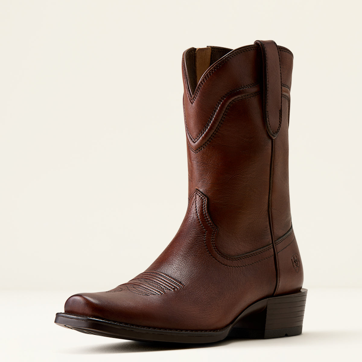 Three-quarter studio profile view of the Ariat Men's Oliver Honey Bee Brown leather Western boot highlighting the narrow cutter toe and dress shaft crease.