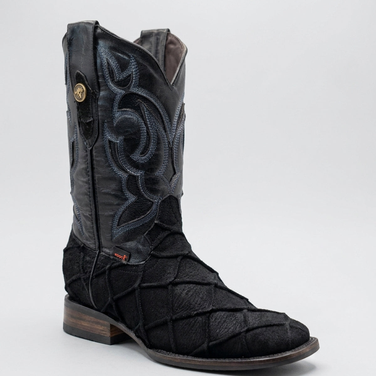 Hooch men's black western cowboy boot featuring a textured pirarucu fish scale print vamp, intricate blue embroidery on the shaft, and a square toe.