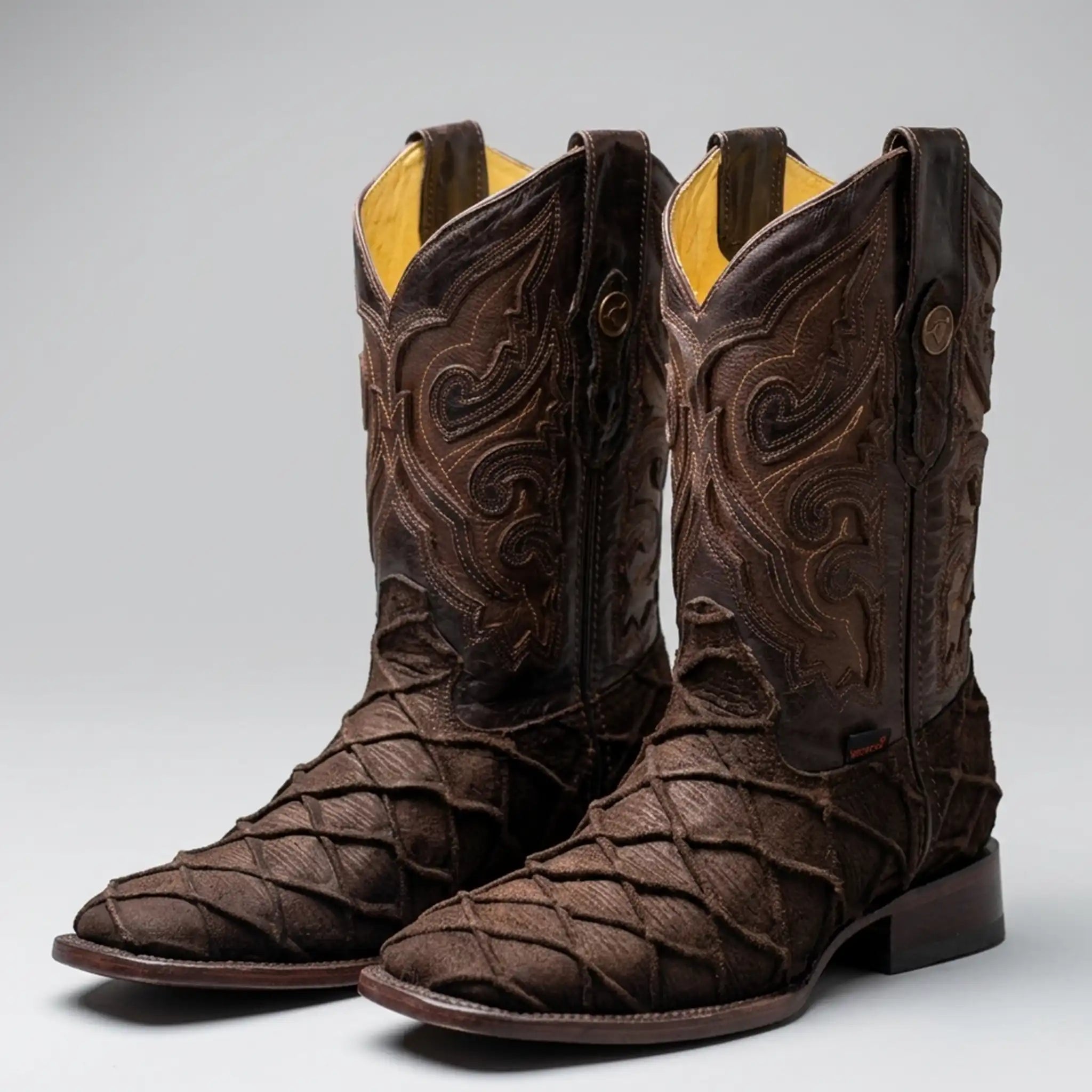 A dark brown Pirarucu fish print western boots with intricate hand-tooled western embroidery on the shaft, a textured woven pattern on the foot, and a square toe, shown against a neutral gray background.