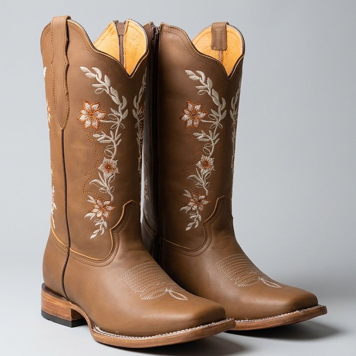 La Sierra tang brown leather square toe cowgirl boots with white floral embroidery on the shafts, shown against a neutral gray background.