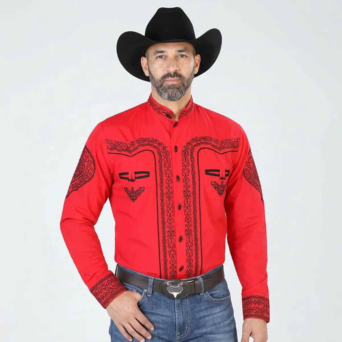 Front view of a male model wearing the men's red traditional embroidered Charro shirt featuring black scroll embroidery, mandarin collar, bone buttons, black felt hat, and jeans.