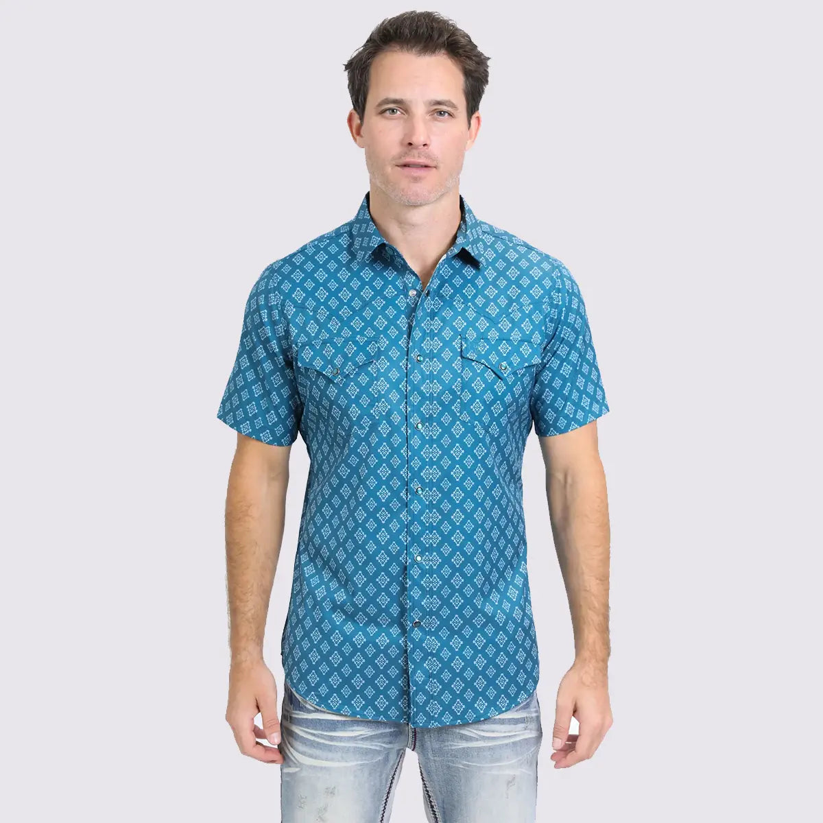 Front studio view of a male model wearing the Platini Men's blue Heritage Aztec short sleeve performance Western shirt with light denim jeans.
