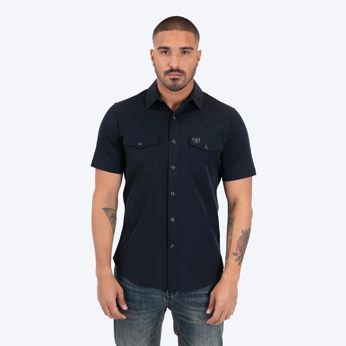 Front studio view of a male model wearing the Platini Men's Prewitt black short sleeve Western performance snap shirt with blue jeans.