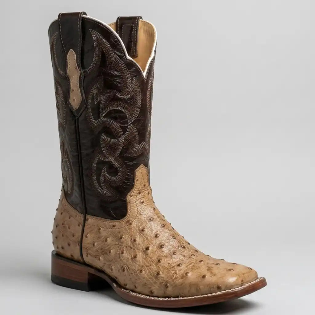 A single western cowboy boot with a tan ostrich print leather foot and a dark brown shaft featuring western embroidery, photographed on a neutral light gray background.