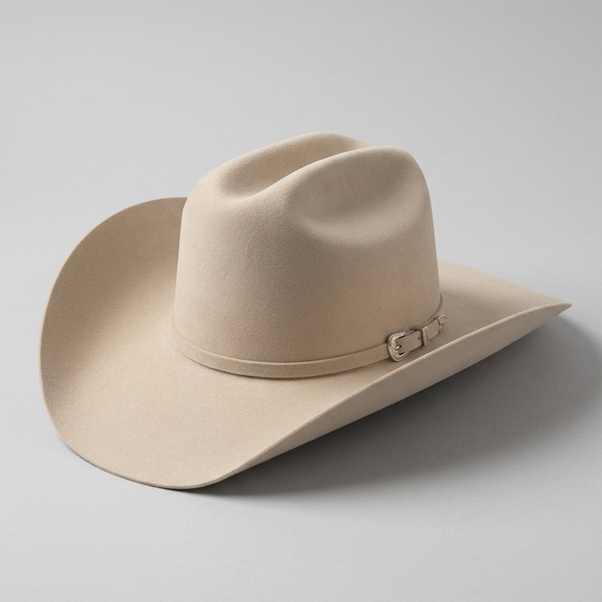 Serratelli light beige felt cowboy hat with a matching band and silver buckle, photographed on a neutral light gray background.