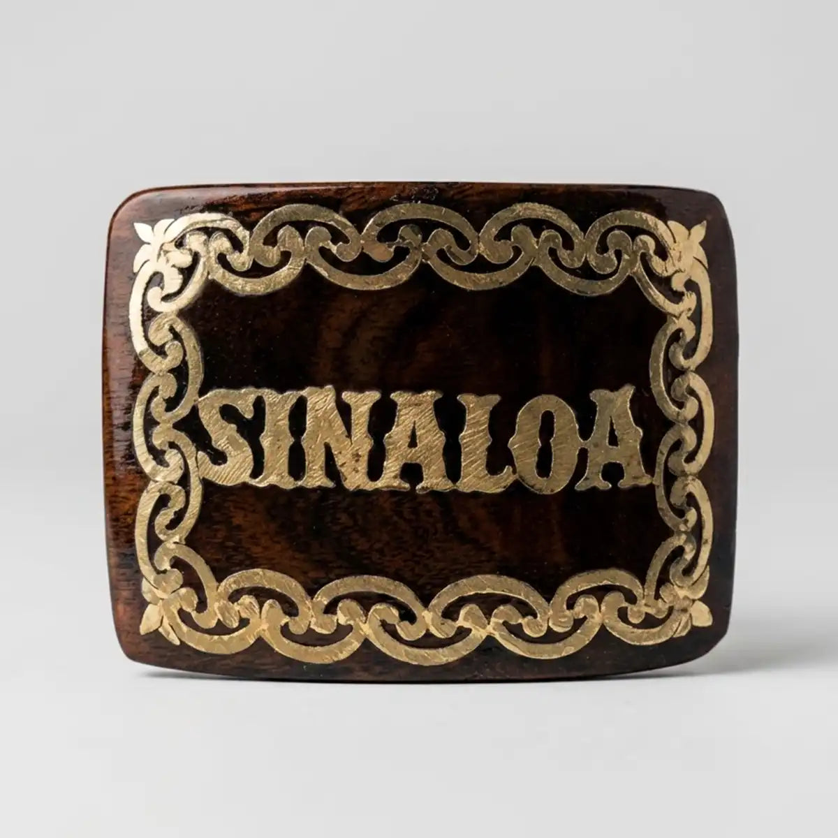 A rectangular wooden belt buckle with rounded corners, featuring a dark brown wood grain finish and an ornate gold-colored filigree border with the word 'SINALOA' in raised gold lettering in the center, set against a light gray background.