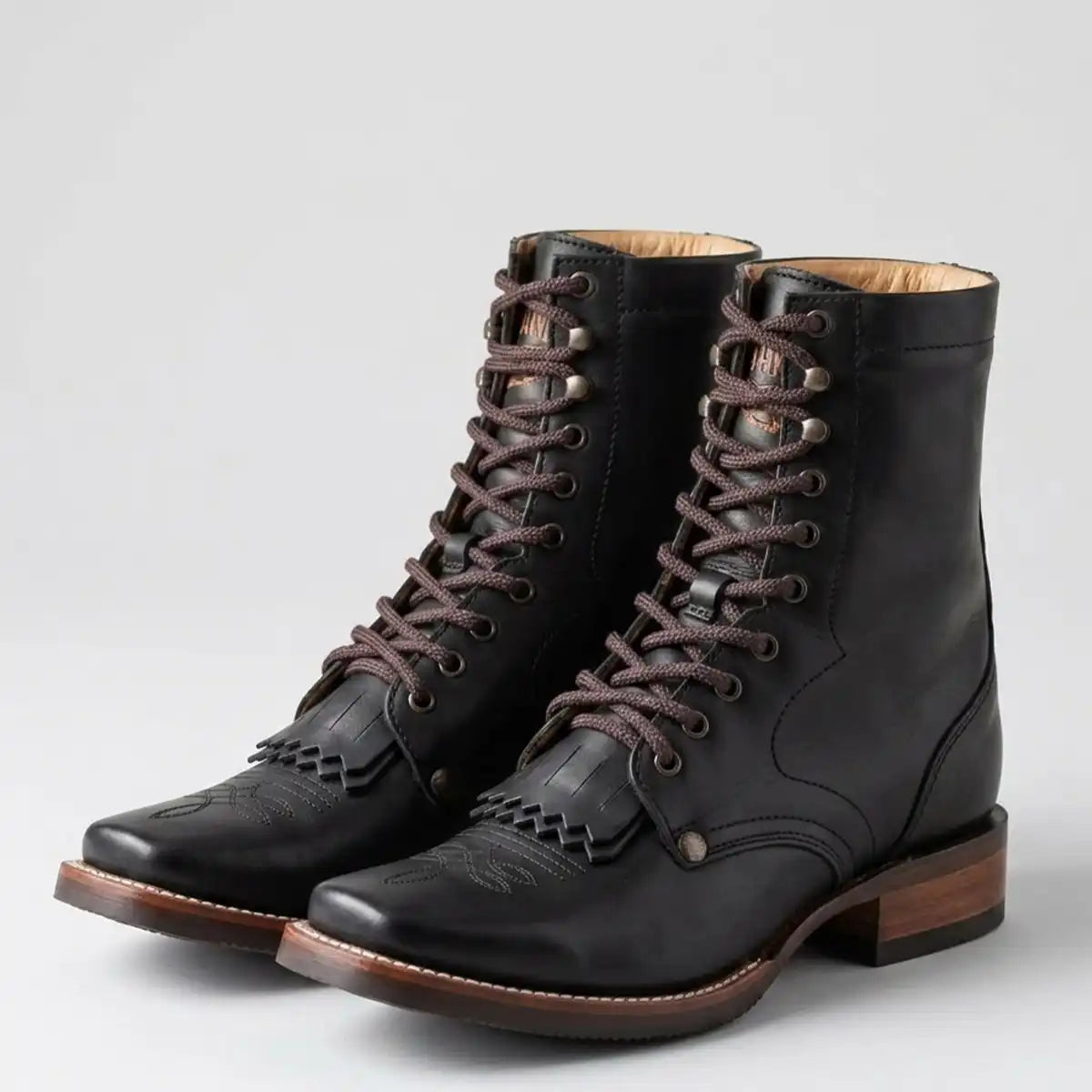 Studio shot of the pair of Tombstone men's black lace-up square toe work boots against a light gray background.