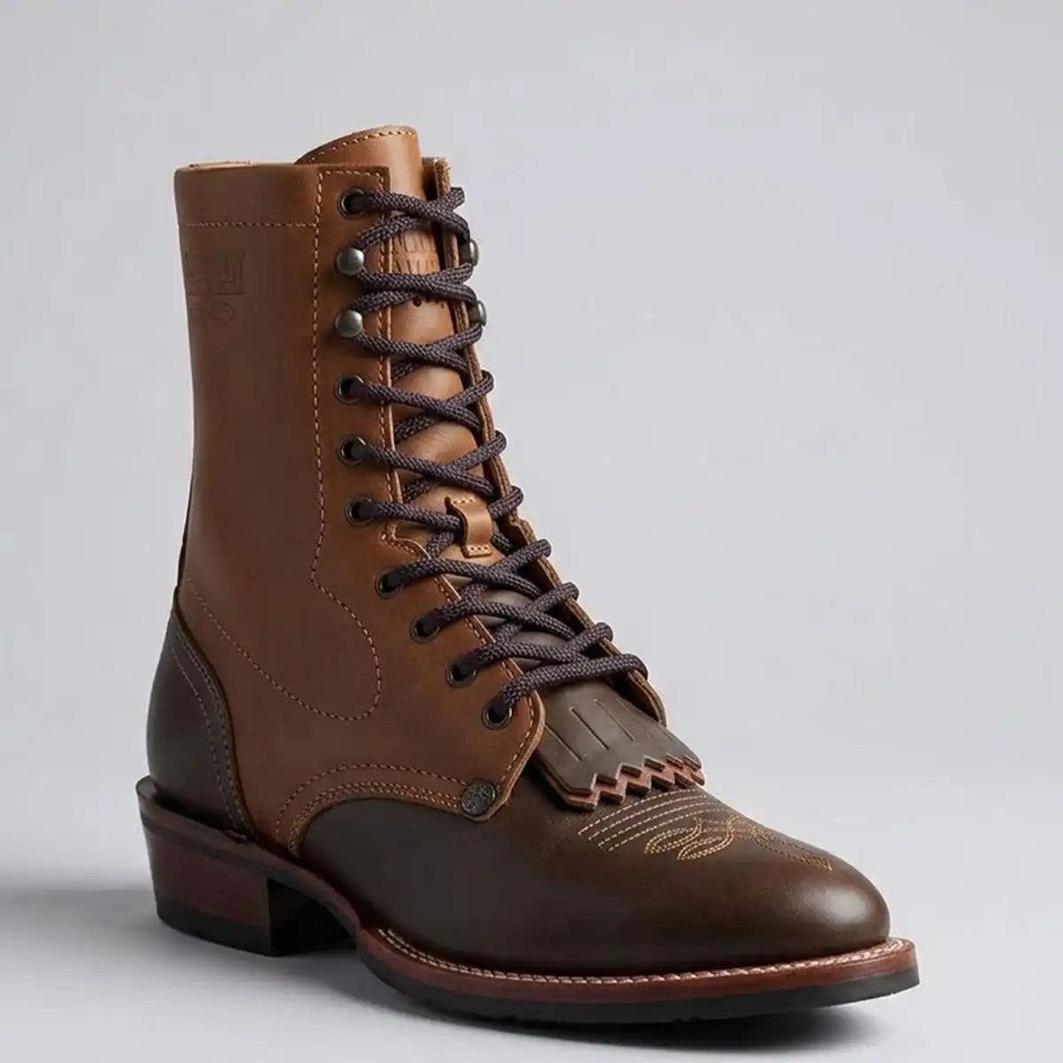 Tombstone men's brown leather lace-up boot with a dark brown toe cap, dark brown laces, and a stacked heel, photographed on a light gray background.