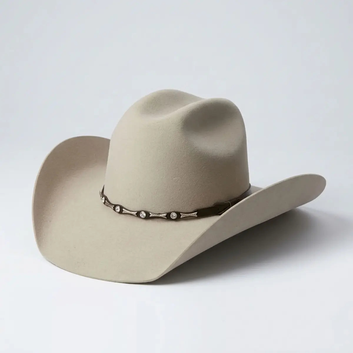 Three-quarter studio profile of the El General Toro sand tan 50X wool Western hat displaying the cattleman crown, 4" brim curvature, and dark studded hatband.