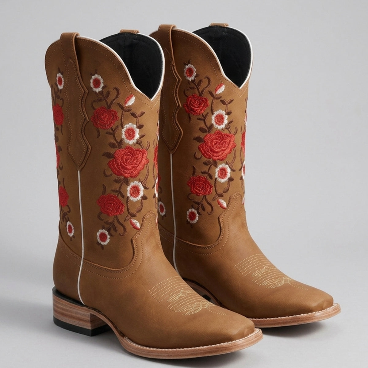 Women's honey tan leather square toe cowgirl boots featuring detailed red and white embroidered floral roses on the shaft.
