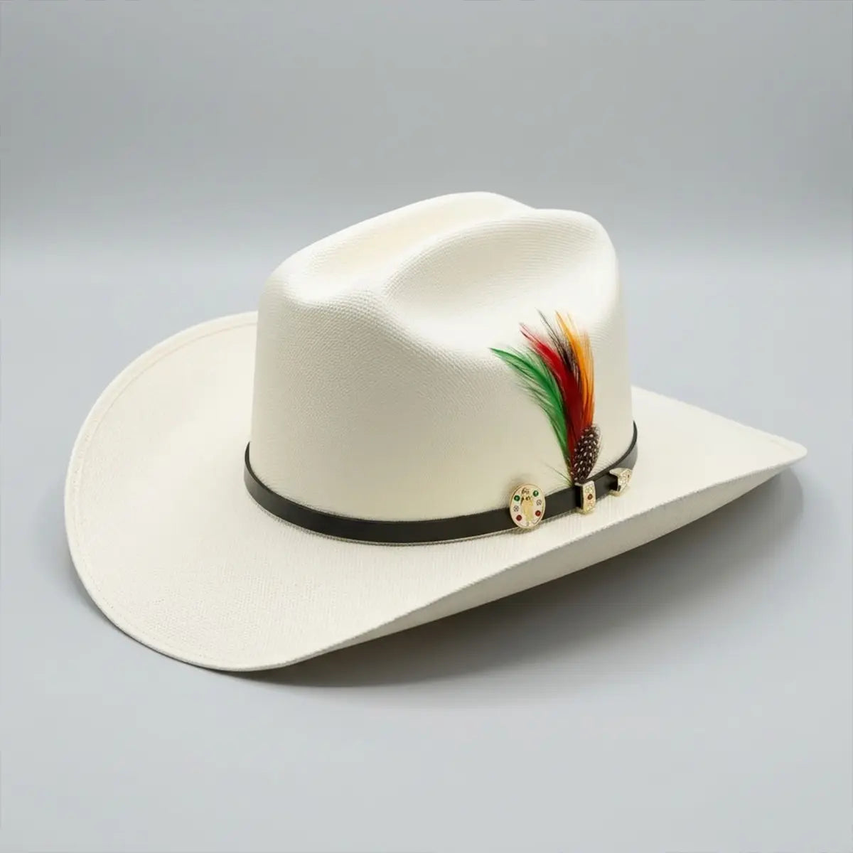 Angled studio view of the Abolengo San Judas Tadeo 1000X Chaparral straw cowboy hat displaying the fine off-white weave, black hatband, gold pin, and feather accent.