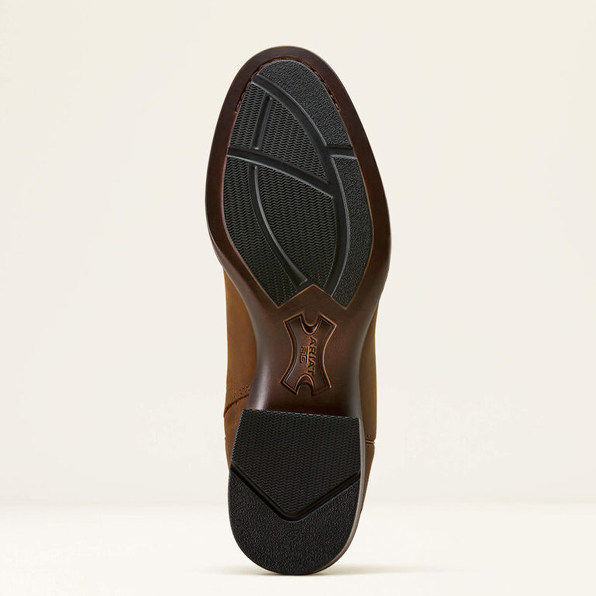 Close-up of a Ariat Sonoro sole with black tread pattern on a beige background.
